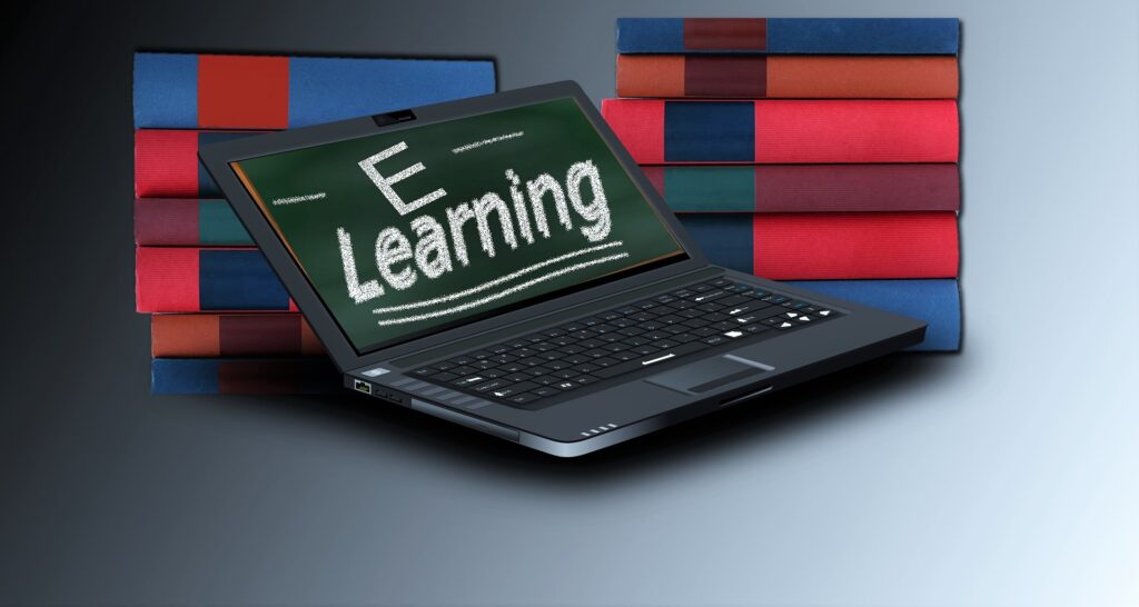 Laptop vor Bücherstapel auf dem e-Learning steht