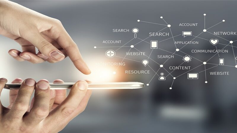 zwei Hände, die ein Smartphone halten. Über dem Smartphone ist eine Wolke mit Begriffen wie Content, Website,Kommunikation